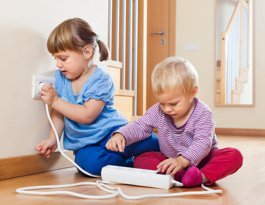 Two children playing with electricity on floor at home