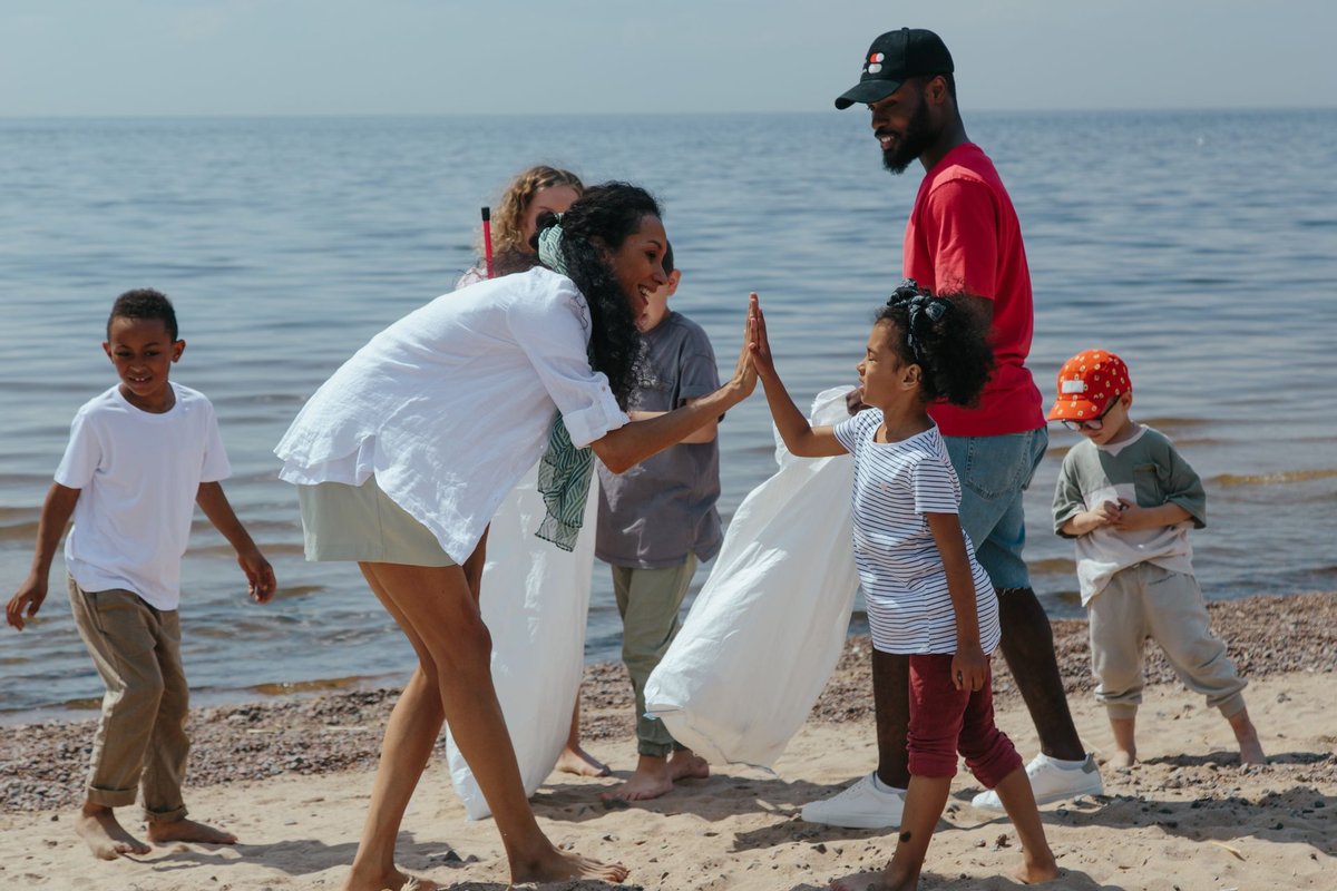 Family and children high-fiving during a beach clean-up