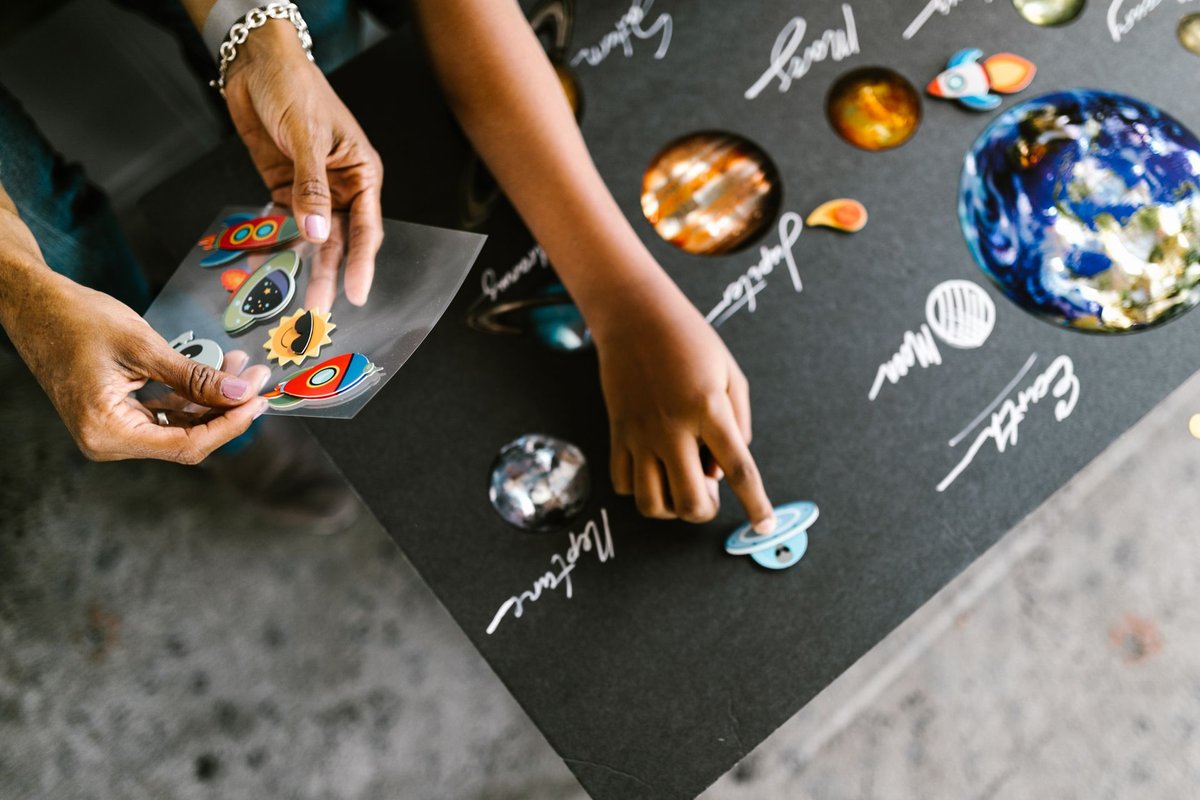Child placing planet stickers on a solar system chart